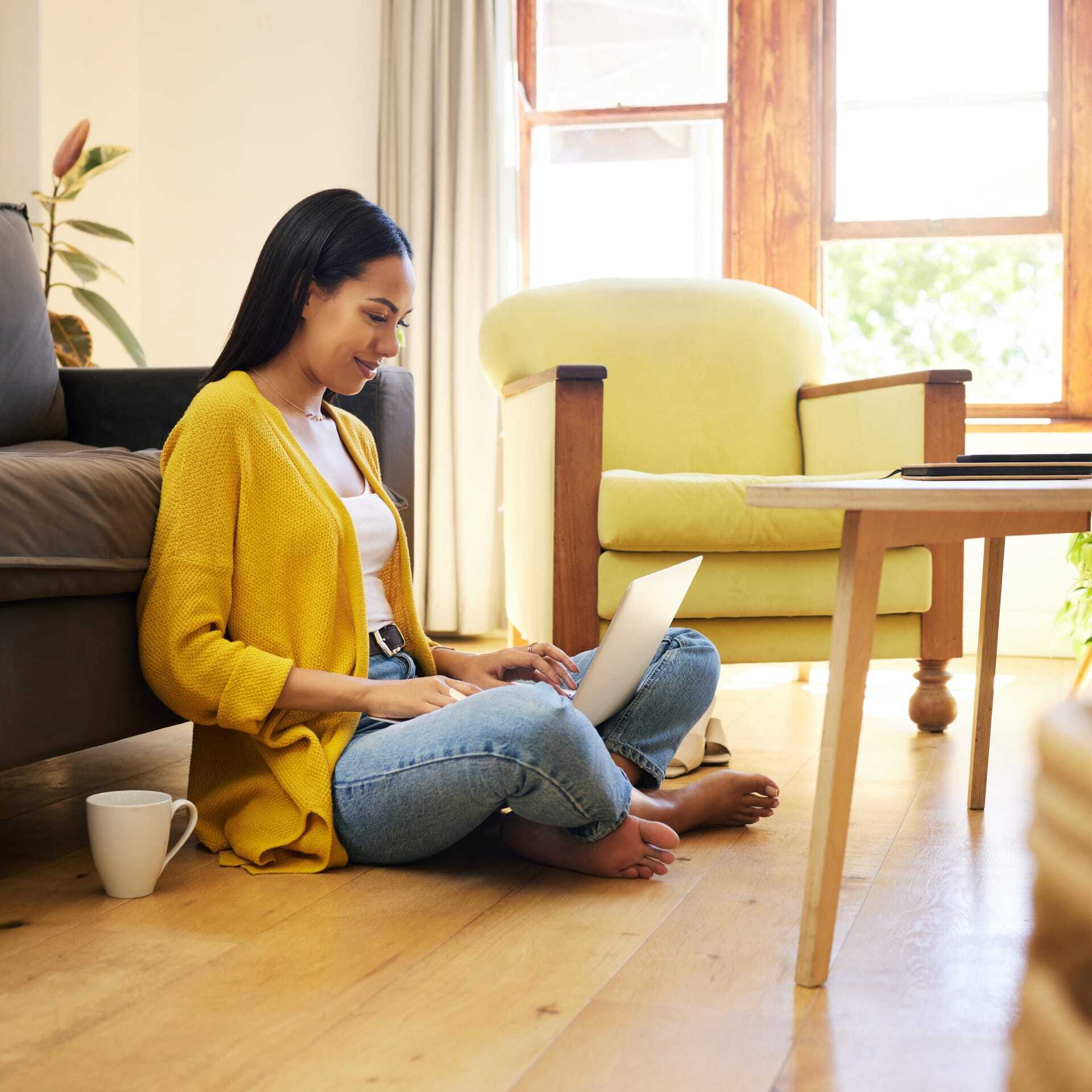 Une femme souriante consultant son ordinateur portable